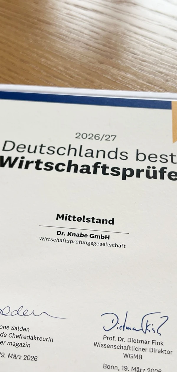Ein Zertifikat, das die Auszeichnung "Deutschlands beste Wirtschaftsprüfer" für die Knabe GmbH im Mittelstand im Jahr 2026/27 zeigt, zusammen mit einem darauf abgestimmten Ehrenpreis.