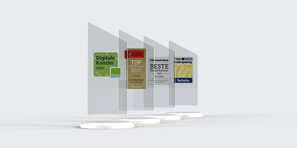 Vier transparente Auszeichnungen stehen auf weißen Sockeln, die jeweils für verschiedene Kategorien ausgezeichnet wurden, darunter "Digitale Kanzlei 2025", "TOP Rechtsanwälte 2023" und "BESTE Steuerberater".