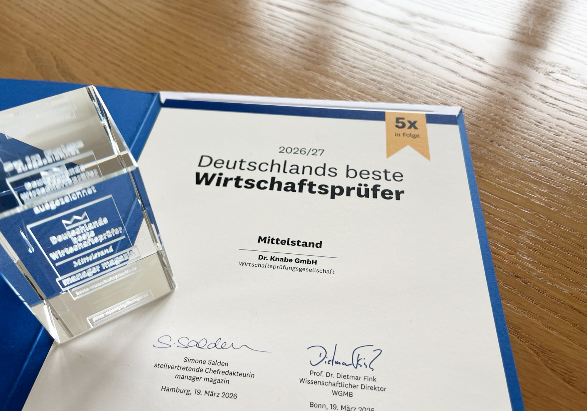 Ein Zertifikat, das die Auszeichnung "Deutschlands beste Wirtschaftsprüfer" für die Knabe GmbH im Mittelstand im Jahr 2026/27 zeigt, zusammen mit einem darauf abgestimmten Ehrenpreis.