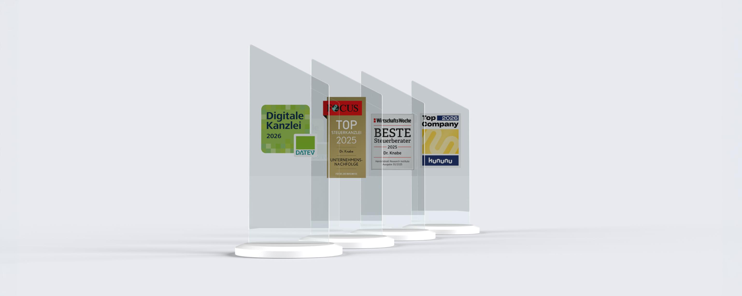 Vier transparente Auszeichnungen stehen auf weißen Sockeln, die jeweils für verschiedene Kategorien ausgezeichnet wurden, darunter "Digitale Kanzlei 2025", "TOP Rechtsanwälte 2023" und "BESTE Steuerberater".